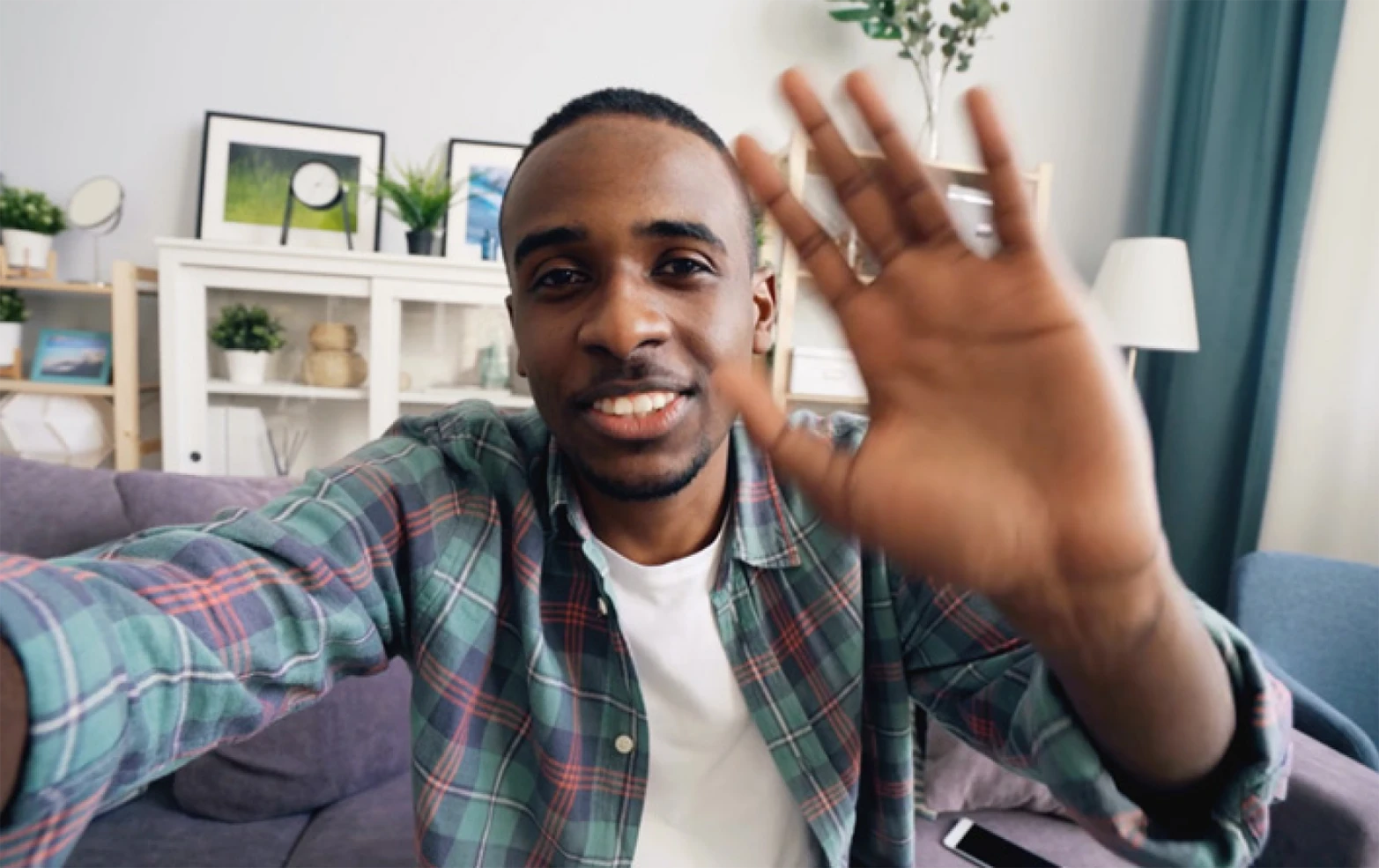 African American man waving at camera taking selfie